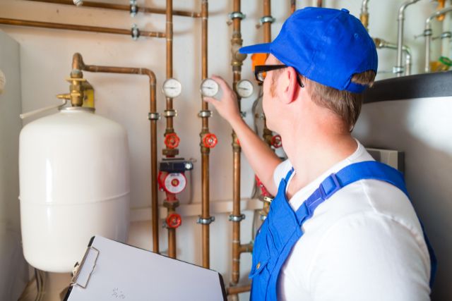 Licensed plumber working on hot water system